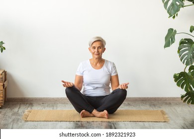 Beautiful Adult Woman Doing Yoga At Home In White T-shirt