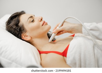 Beautiful Adult Woman During An Ultrasound Examination Of Thyroid Gland, Lying At Medical Office. Endocrine System Health Concept