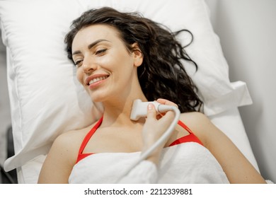 Beautiful Adult Woman During An Ultrasound Examination Of Thyroid Gland, Lying At Medical Office. Endocrine System Health Concept