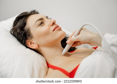 Beautiful Adult Woman During An Ultrasound Examination Of Thyroid Gland, Lying At Medical Office. Endocrine System Health Concept