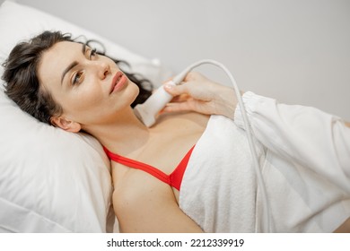 Beautiful Adult Woman During An Ultrasound Examination Of Thyroid Gland, Lying At Medical Office. Endocrine System Health Concept