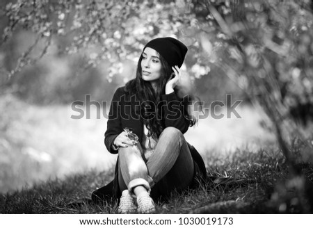 Similar – Beautiful young photographer woman wearing black clothes, sitting on the floor in countryside with her camera