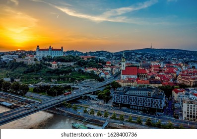 Beautiful aerial photo of Bratislava city and castle above Danube river at sunset in summer from drone. Beautiful shot of capital of Slovakia with St. Martin's Cathedral, Kamzik TV tower and old town.