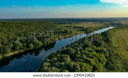 Beautiful aerial shot of an untouched wild river landscape. Gorgeous summer view of a river flowing through the untouched forest on a bright spring day. A drone shot of a wild natural river terrain. 