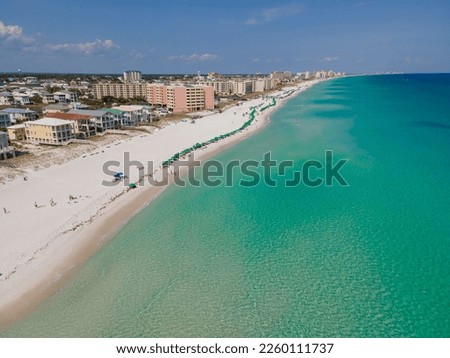 Beautiful aerial view of beach and ocean at East Jetty in Destin Florida. Scenic nature landscape with buildings and houses overlooking the sandy shore and clean water.