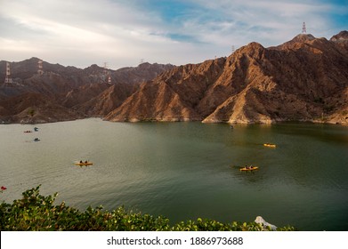 BEAUTIFUL AERIAL VIEW OF  BOATS, KAYAKS IN THE RAFIS WATER DAM  AT SUNSET TIME IN THE MOUNTAINS ENCLAVE REGION OF KHOR FAKKAN, SHARJAH UNITED ARAB EMIRATES