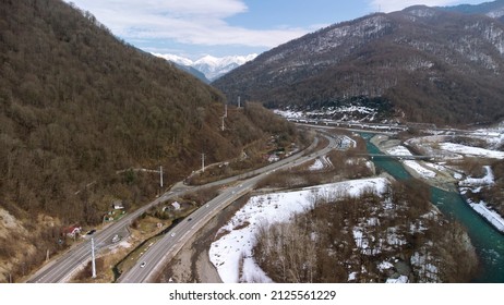 Beautiful Aerial View Of The Highway Between The Snow-capped Mountains. Sochi, Krasnaya Polyana, Russia.