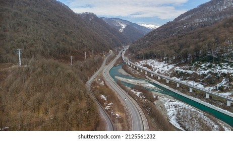 Beautiful Aerial View Of The Highway Between The Snow-capped Mountains. Sochi, Krasnaya Polyana, Russia.