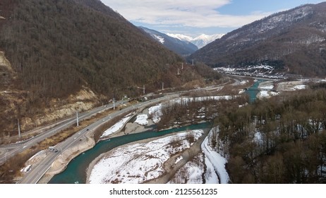 Beautiful Aerial View Of The Highway Between The Snow-capped Mountains. Sochi, Krasnaya Polyana, Russia.