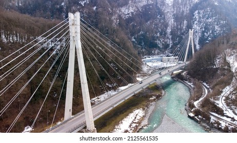 Beautiful Aerial View Of The Highway Between The Snow-capped Mountains. Cable-stayed Bridge. Sochi, Krasnaya Polyana, Russia.