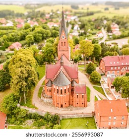 A beautiful aerial view of a historic brick church located in a charming village. The church's intricate architecture and the surrounding greenery create a picturesque scene. - Powered by Shutterstock