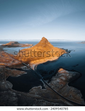 Beautiful aerial view of the Kirkjufell high mountain in Iceland, on the Snaefellsnes peninsula. Sunset Sunrise soft orange light. West Iceland.