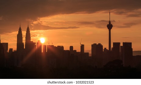 Beautiful Aerial View Of Kuala Lumpur City Skyline, Skyscraper During Sunrise With Dramatic Sky, Clouds And Sun Rays.