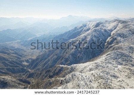 Beautiful aerial view of snow covered pine forests. Rime ice and hoar frost covering trees. Scenic winter landscape of Baizhangling, Lin'an, Hangzhou, Zhejiang, China. Drone landscape in winter.