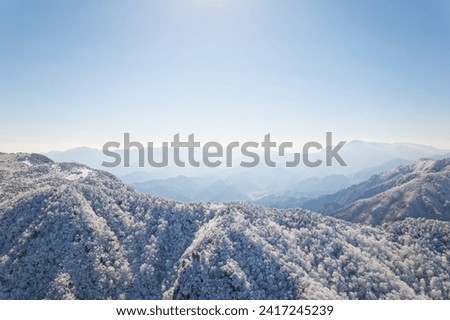 Beautiful aerial view of snow covered pine forests. Rime ice and hoar frost covering trees. Scenic winter landscape of Baizhangling, Lin'an, Hangzhou, Zhejiang, China. Drone landscape in winter.