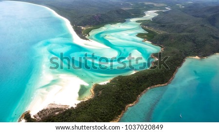 A beautiful aerial view of turquoise waters, white sandy beaches and green forests in the paradise of the Whitsunday's islands, Australia. Concept for summer, holidays and travelling