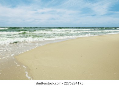 Beautiful aesthetics sea waves and sand beach, blue clouds sky, seascape background. Scenic landscape with turquoise sea water as screensaver, wallpaper. Sparkling waves ocean, beauty nature, sunlight