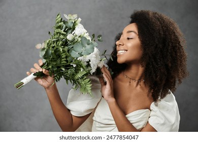 A beautiful African American bride in a white wedding dress smiles while holding a bouquet of flowers. - Powered by Shutterstock