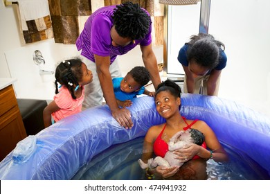 A beautiful African American family discussing the newest addition to their family after she is born at home.  