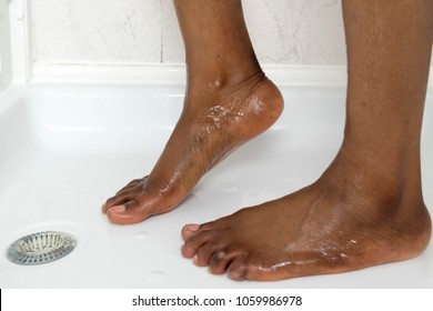 Beautiful African American Female Feet Under The Shower In The Bathroom. Close-up Of A Unrecognizable Woman Feet Selective Focus. Close Up Of Wet Legs In The Bathroom.   