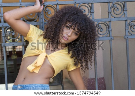 Similar – Young woman with curly hair near a modern colorful building