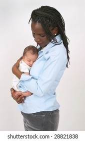 A Beautiful African American Lovingly Holding A White Or Mixed Race Newborn Child