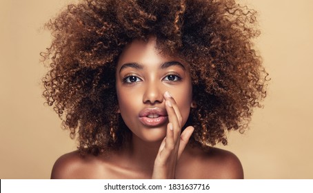 Beautiful african american woman with afro hair   telling a secret .Portrait  beauty  girl who is calling to someone .Funny  model  whispering about something. Expressive facial expressions