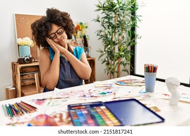 Beautiful african american woman with afro hair painting at art studio sleeping tired dreaming and posing with hands together while smiling with closed eyes.  - Shutterstock ID 2151817241