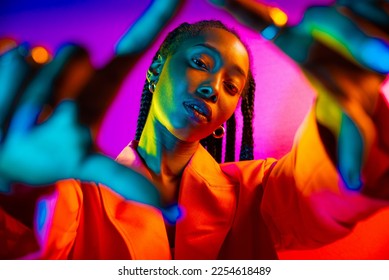 Beautiful african american woman with afro pigtails hairstyle and stylish clothes - Portrait of young black girl in studio, creative colorful lighting technique on colored background in studio