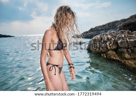 Beautiful african american  woman bathing in the sea on a sunny summer holiday, wet hair, coastal exterior. Adolescent travel lifestyle enjoying the clear sea beach.