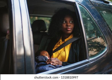 Beautiful African American Woman Holding A Baby In A Car Back Seat