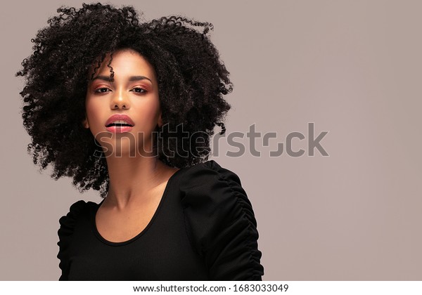 カメラを見る美しいアフリカ系アメリカ人の女性 アフロの髪型の明るい若い女性のポートレート 巻き毛の美人 の写真素材 今すぐ編集