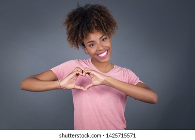 Beautiful African American woman over isolated background smiling in love showing heart symbol and shape with hands. Romantic concept. - Powered by Shutterstock