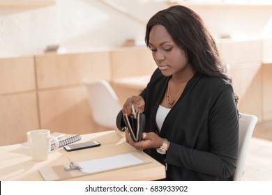 Beautiful African American Woman Paying For Coffee With Cash In Cafe 