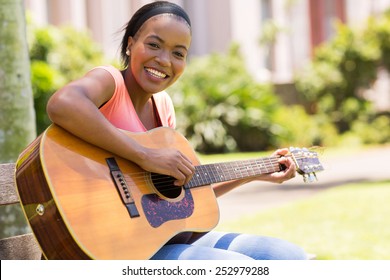 Beautiful African American Woman Playing Guitar Outdoors