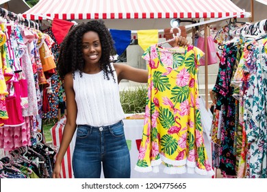 Beautiful African American Woman Selling Clothes To Customers At Typical Market