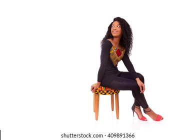 Beautiful African American Woman Sitting On A Stool Isolated On White Background