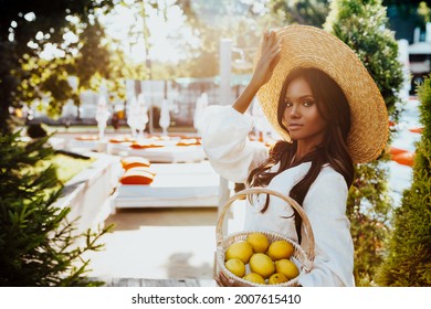 Beautiful African American Woman in Straw Hat. black girl outdoors enjoying a vacation in Italy and ripe lemons          - Powered by Shutterstock