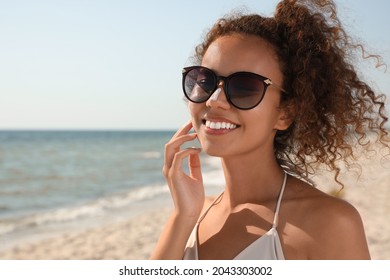 Beautiful African American woman with sun protection cream on nose at beach - Powered by Shutterstock