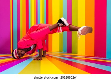 Beautiful african american young woman dancer having fun inside a rainbow box room - Cool and stylish adult woman portrait on multicolored background, influencer creating content for social networks