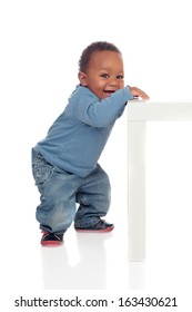 Beautiful African Baby Standing With A Table Isolated On A White Background