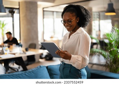 Beautiful African businesswoman using digital tablet in office. Young woman having video call.  - Powered by Shutterstock
