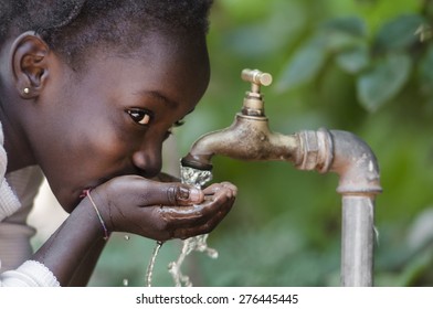 Beautiful African Child Drinking from a Tap (Water Scarcity Symbol).

Young African girl drinking clean water from a tap. Water pouring from a tap in the streets of the African city Bamako, Mali.