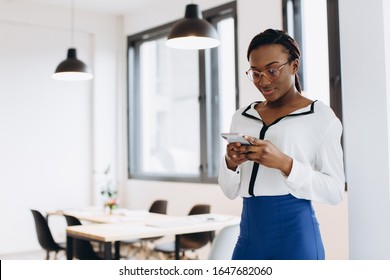 Beautiful African Corporate Worker Talking On Mobile Phone In Modern Office