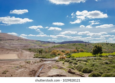 Beautiful African scenery in Morocco, green fields, blue sky, red sands