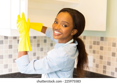 Beautiful African Woman Cleaning Cupboard