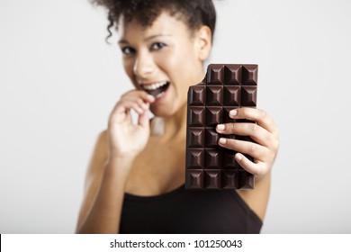 Beautiful African Woman Holding And Eating A Huge Dark Chocolate Bar