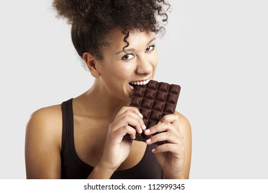 Beautiful African Woman Holding And Eating A Huge Dark Chocolate Bar