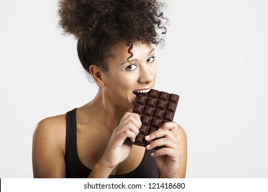 Beautiful African Woman Holding And Eating A Huge Dark Chocolate Bar