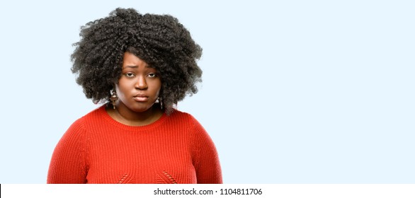 Beautiful african woman with sad and upset expression, unhappy, blue background
